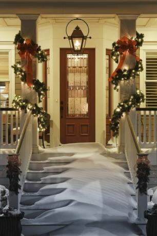 innbydende juleåpning med snø på veranda trapp og rekkverk